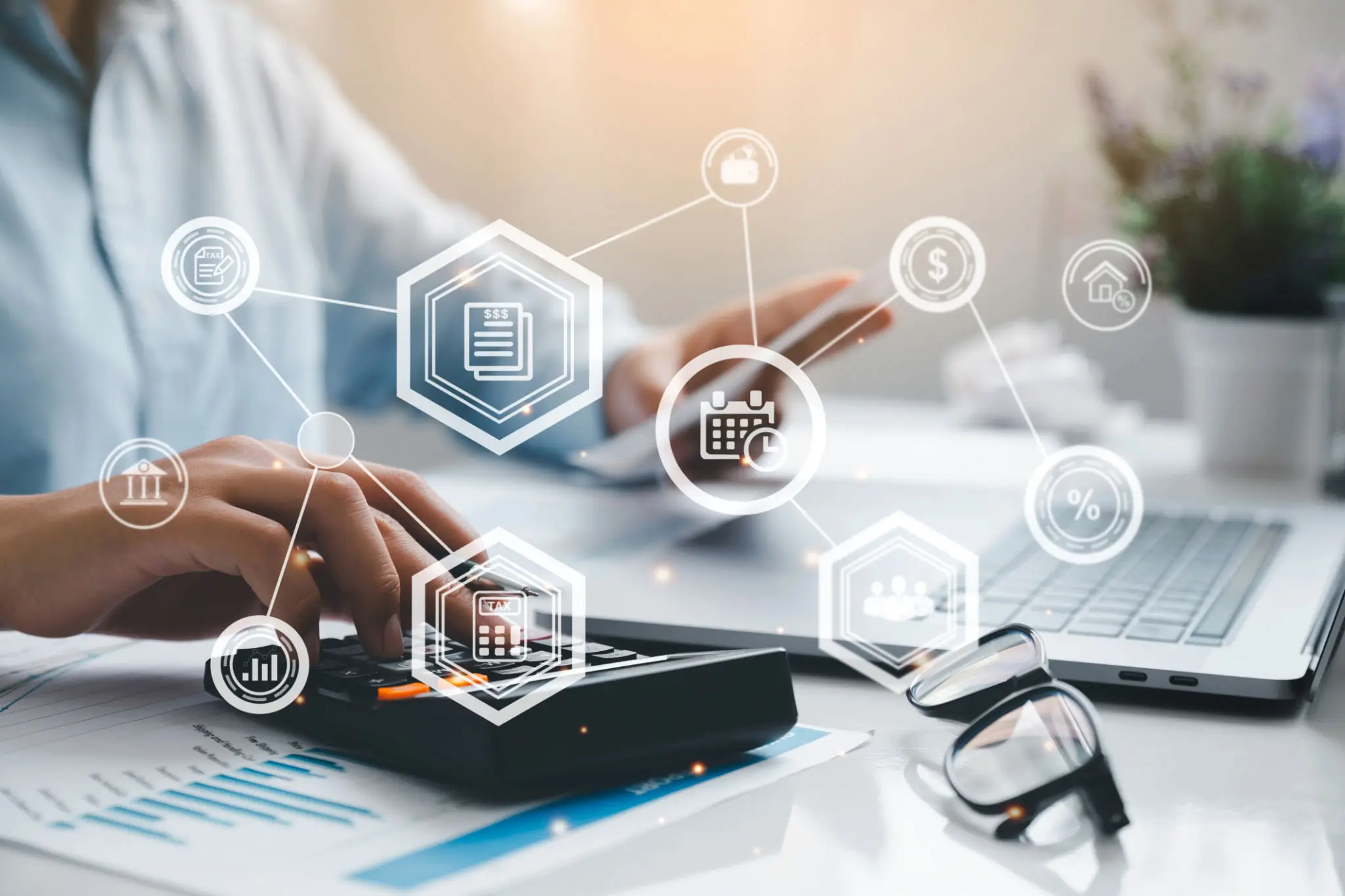 Person using calculator with financial icons overlayed, symbolizing digital finance.